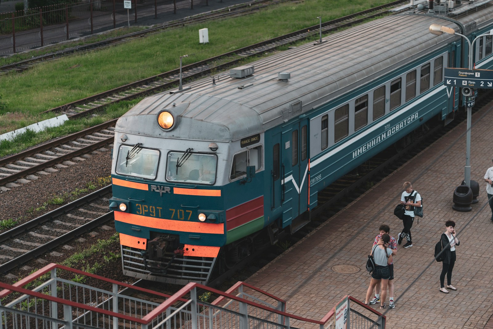 blue green and red train on rail tracks during daytime